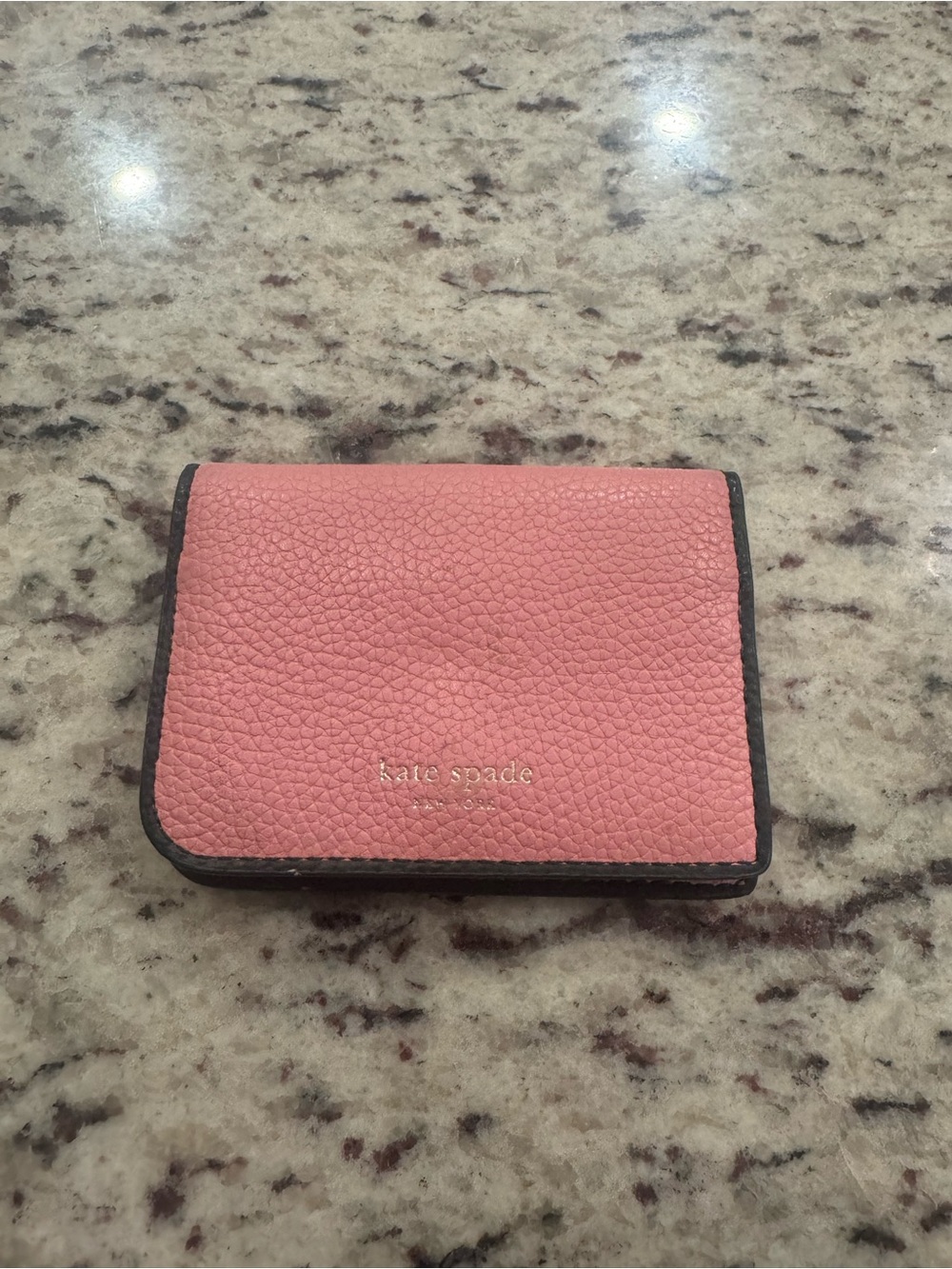 kate spade pink pebbled wallet with black trim and gold logo